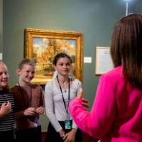 students answering questions from Jennifer Moss, WGVU, with their poster